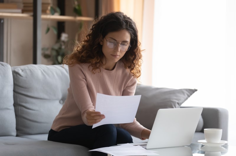 Como é cobrado a taxa condominial? | Foto de uma moça analisando um documento com atenção | Viver em condomínio | Blog da Tenda