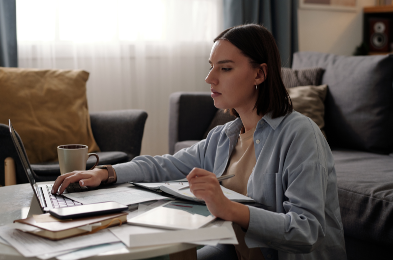 O que é Custo Efetivo Total | Mulher organizando as contas usando um notebook | Tenda Explica | Blog da Tenda