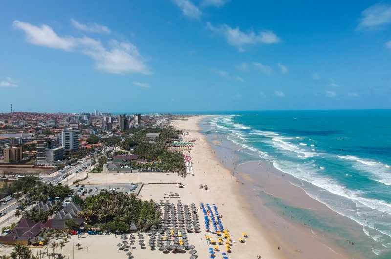 Praia do Futuro | Vista aérea de uma praia movimentada com cidade ao fundo | Onde Morar | Blog da Tenda 