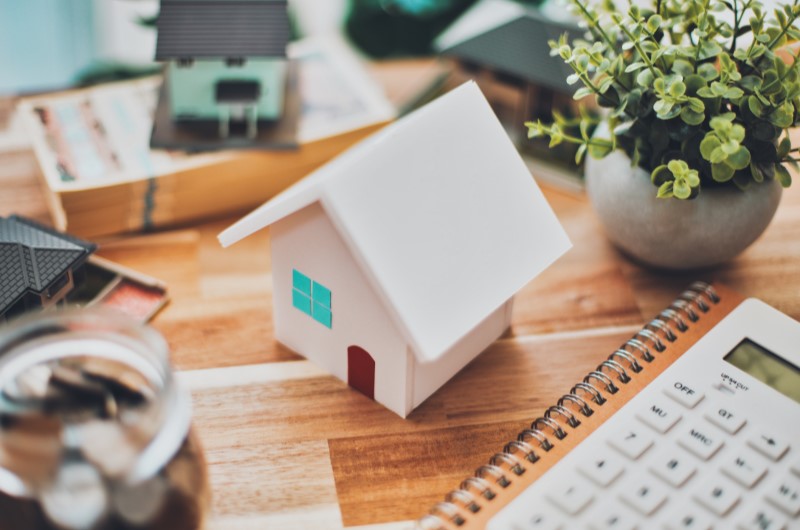 Como funciona o Minha Casa, Minha Vida | Casa em miniatura sobre mesa com calculadora e plantas | Minha Casa, Minha Vida | Blog da Tenda 