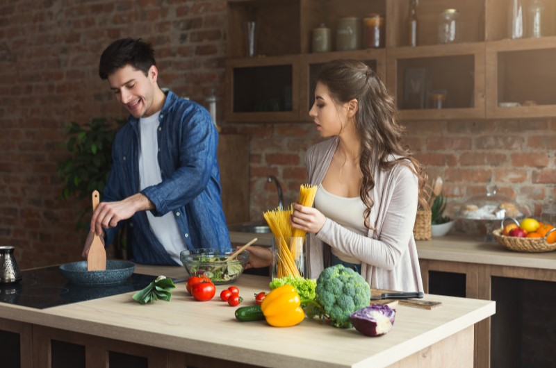 Desvantagens da cozinha em conceito aberto | Casal cozinhando juntos em cozinha rústica | Casa e Decoração | Blog da Tenda 