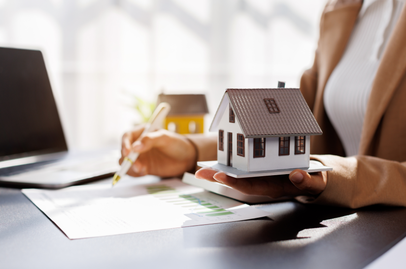 O que é ágio de apartamento | Mulher segurando maquete de casa e analisando contrato | Tenda Explica | Blog da Tenda