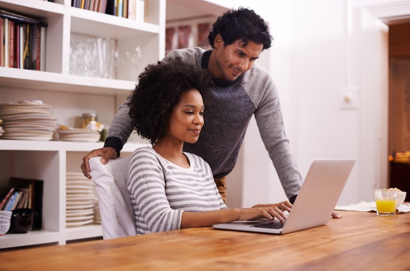 Custo de vida | Casal usando notebook em casa | Onde Morar | Blog da Tenda 