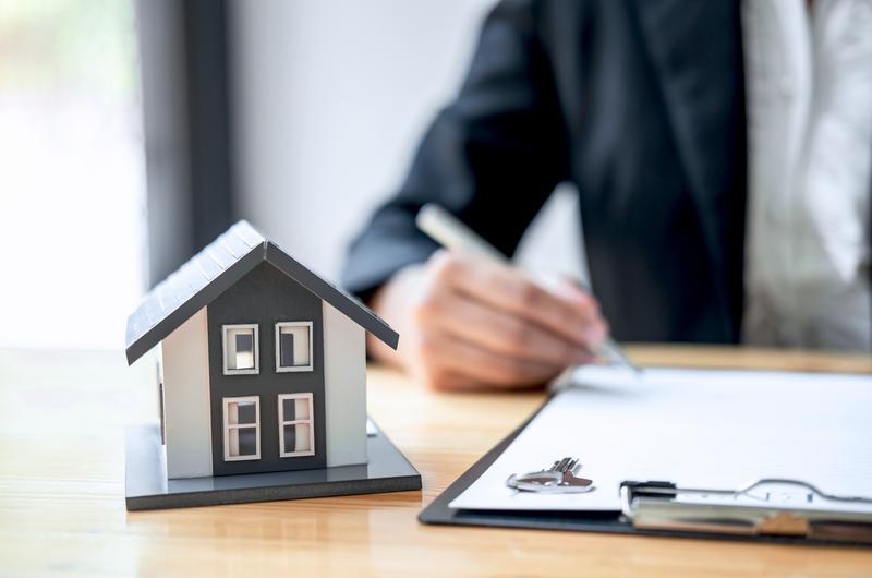 O que é score para financiamento | Pessoa escrevendo em documento com casinha ao lado | Trilha da Conquista | Blog da Tenda 