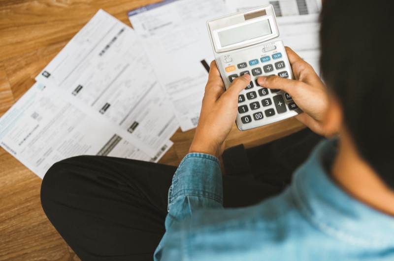 Como diminui juros de dívidas | Foto de uma pessoa fazendo contas na calculadora | Dúvidas sobre dívidas | Eu Dou Conta