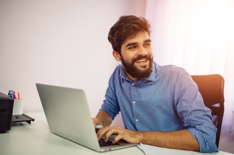 Como fazer primeira venda de afiliado | Foto de um homem trabalhando feliz na internet | Economia e renda extra | Eu Dou Conta