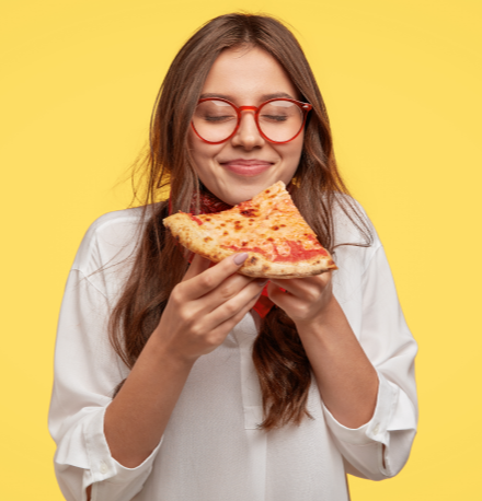 29 dicas para economizar na alimentação | Foto de uma moça segurando um pedaço de pizza | Economia e renda extra | Eu Dou Conta