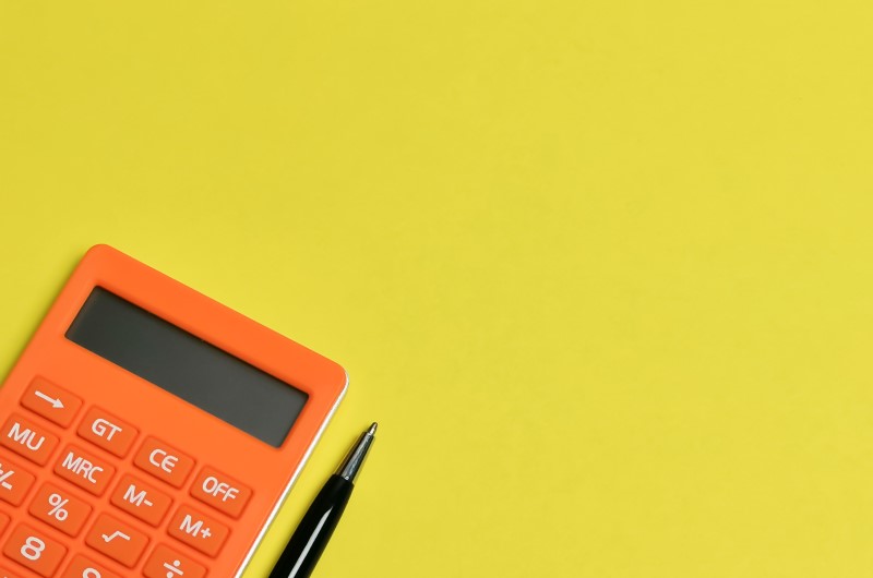 Quanto economizar por mês | Foto de uma calculadora e uma caneta | Economia e renda extra | Eu Dou Conta