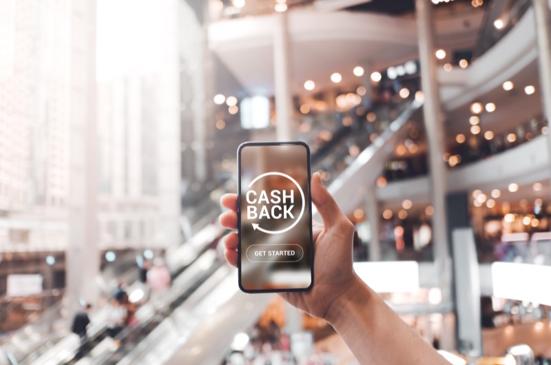 Cashback Black Friday | Foto de uma pessoa segurando um celular em uma tela de cashback | Economia e renda extra | Eu Dou Conta