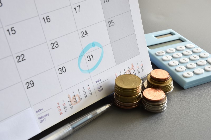 Quando vai ser pago o décimo terceiro | Foto de um calendário, uma calculadora e moedas | Economia e renda extra | Eu Dou Conta