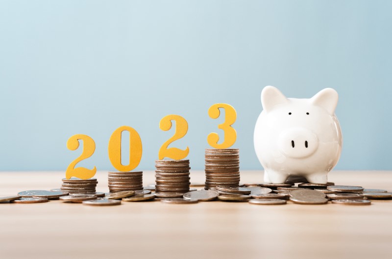 Como fazer um planejamento financeiro para 2023 | Foto de um cofrinho de porquinho, moedas e o número 2023 | Como limpar o seu nome | Eu Dou Conta