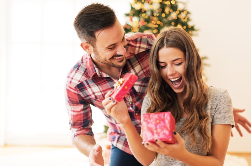 O que dar de presente de Natal | Foto de um namorando entregando um presente de Natal para a namorada | Economia e renda extra | Eu Dou Conta