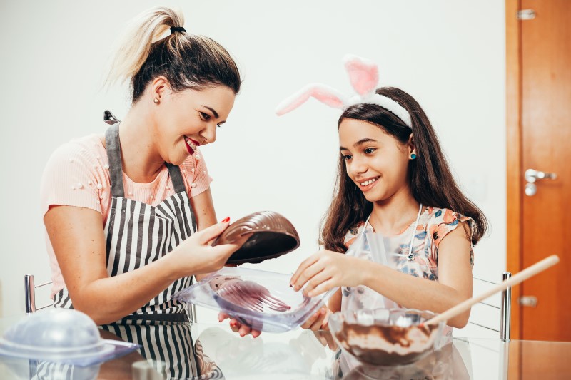 Como fazer ovo de páscoa caseiro | Foto de uma mulher fazendo ovo de páscoa com uma menina | Economia e renda extra | Eu Dou Conta