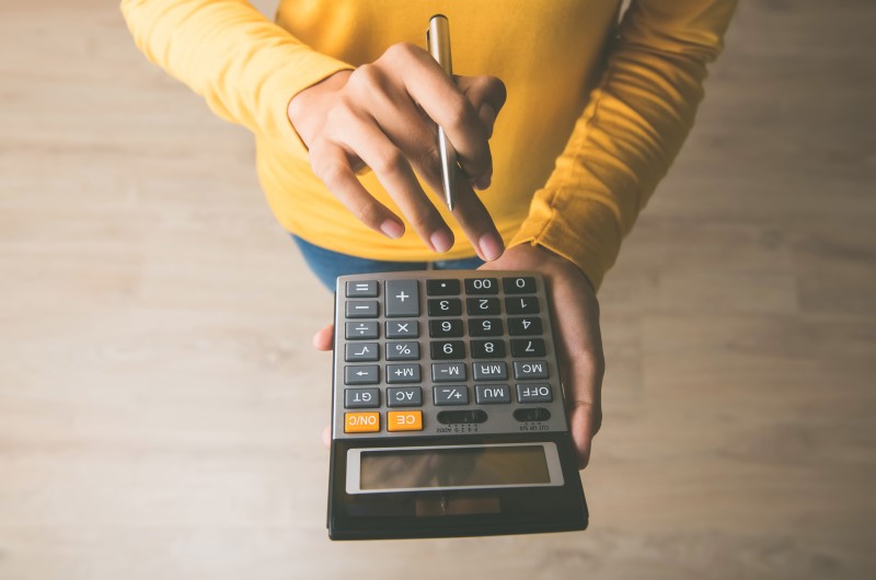 Financiamento | Foto de uma pessoa segurando uma calculadora | Dúvidas sobre dívidas | Blog Eu Dou Conta 