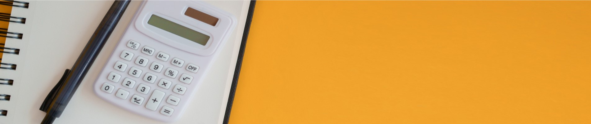 Tipos de empréstimo | Foto de uma calculadora e caneta em cima de um caderno que está em um fundo amarelo | Dúvidas sobre dívidas | Blog Eu Dou Conta