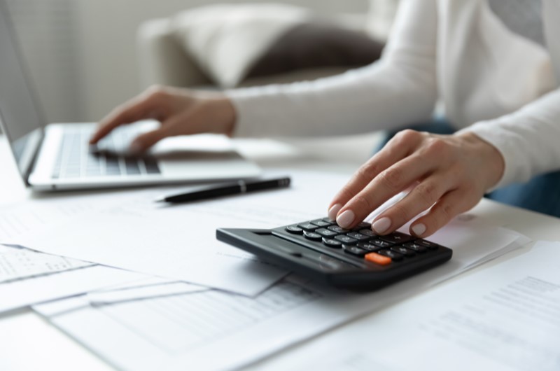 Autofinanciamento | Foto de uma pessoa usando o notebook e calculadora | Dúvidas sobre dívidas | Eu Dou Conta 