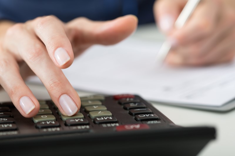 Faça uma previsão do orçamento | Foto de uma pessoa usando a calculadora para fazer contas | Economia e renda extra | Eu Dou Conta 