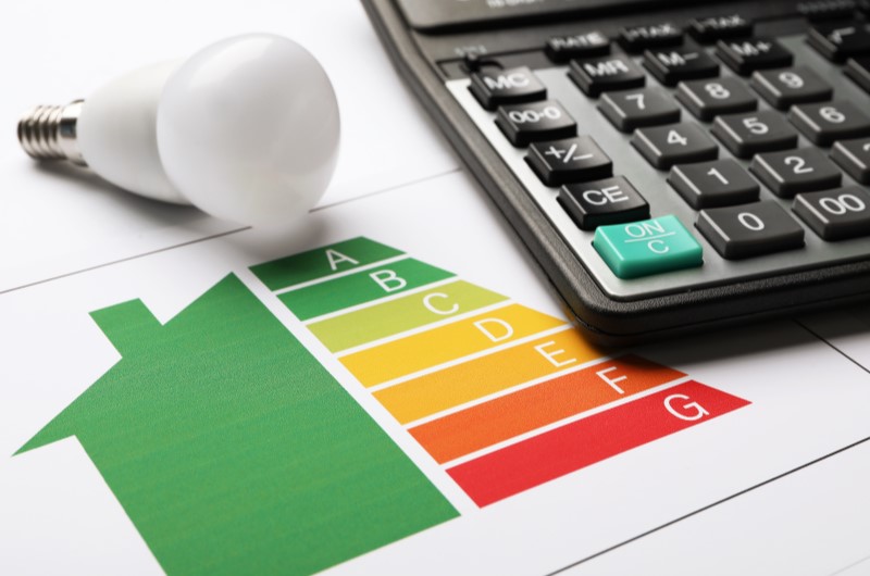 Qual a importância de economizar energia? | Foto de uma calculadora, uma lâmpada e um papel | Economia e renda extra | Eu Dou Conta 