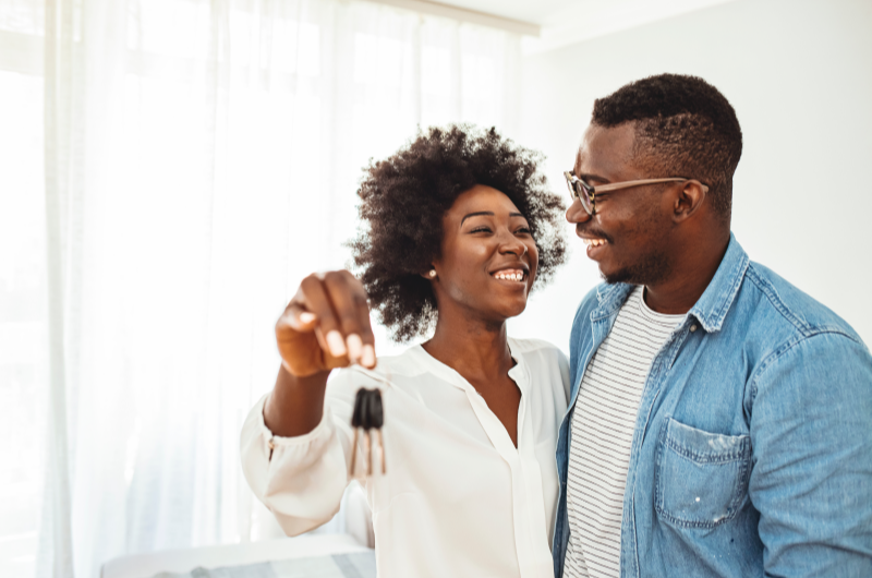 Como se organizar para comprar um apartamento? | Foto de um casal feliz segurando as chaves da casa própria | Economia e renda extra | Eu Dou Conta 