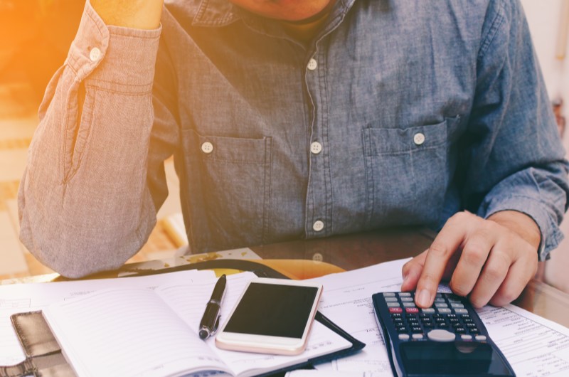 Qual a importância de organizar as finanças pessoais? | Foto de uma mulher segurando um papel na frente do notebook | Economia e renda extra | Eu Dou Conta 