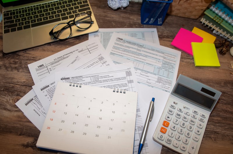 O que é Nota Fiscal Denegada? | Foto de um calendário, notebook, calculadora e papeis sobre a mesa | Dúvidas sobre dívidas | Eu Dou Conta 